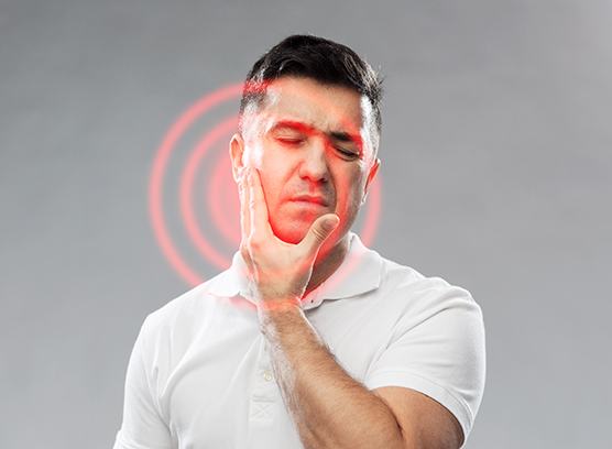 Man grimacing due to toothache pain