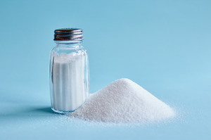 Pile of salt next to salt shaker